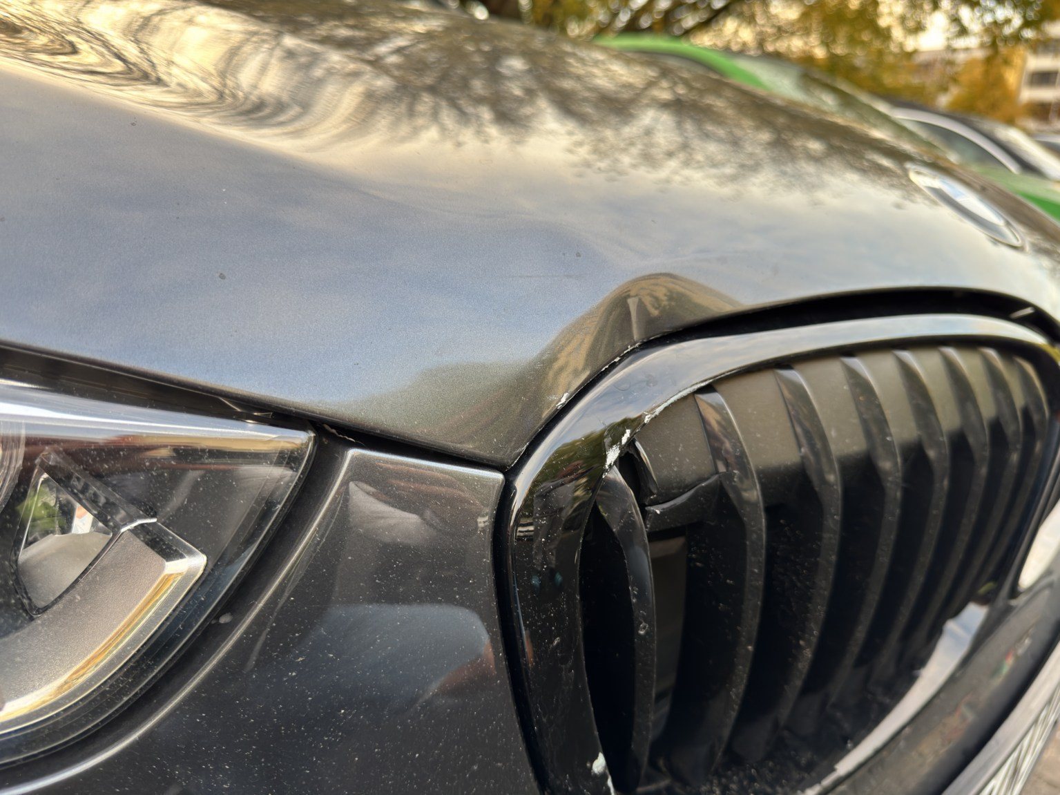 Frontdetail: eingedrückte Motorhaube über dem Kühlergrill des BMW X1