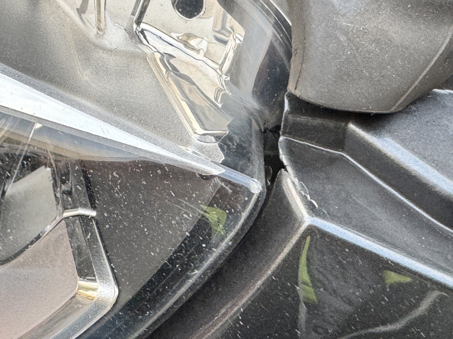 Schadendetail: gerissener Scheinwerfer und verformte Frontverkleidung