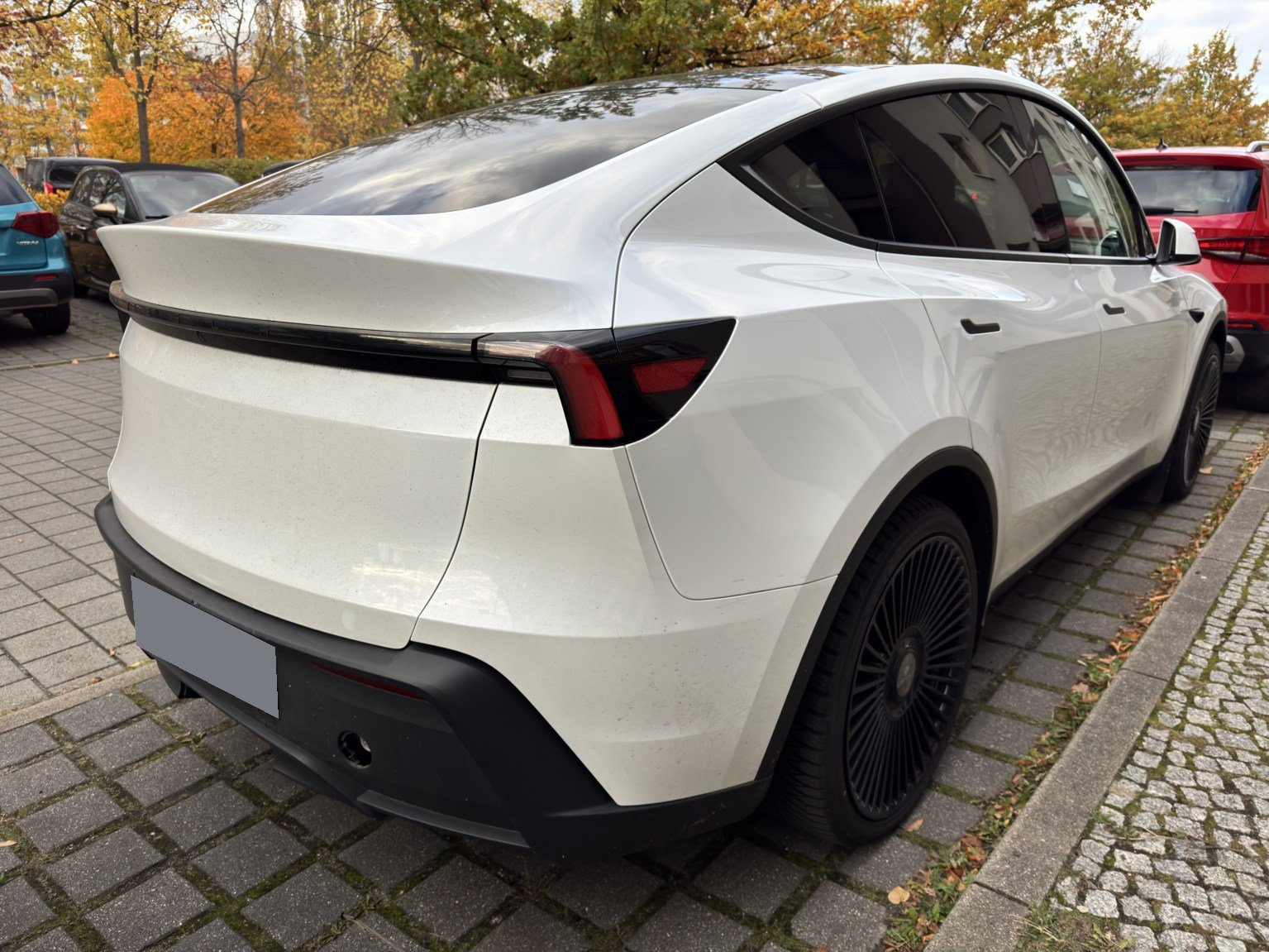 Weißer Tesla Model Y von hinten links beim Ortstermin am CARCHECK-BERLIN-Büro, Kennzeichen unkenntlich gemacht