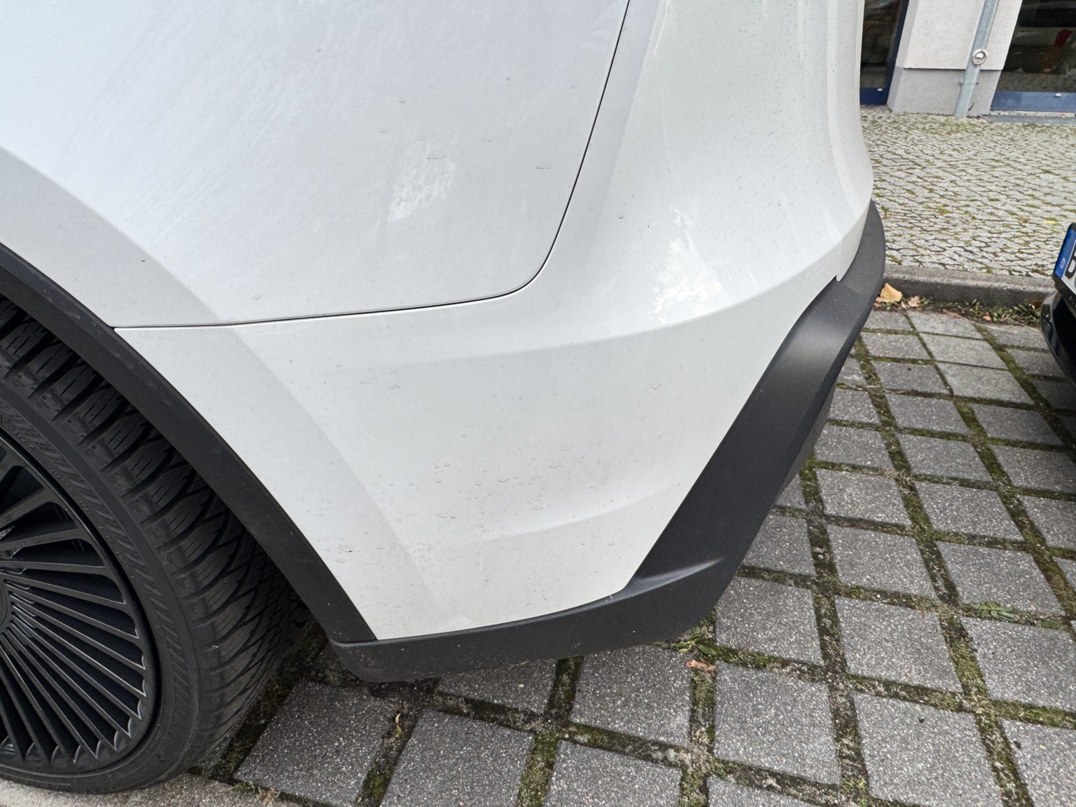 Hintere Ecke des Tesla Model Y mit Radlauf und Stoßfängerecke von der Seite