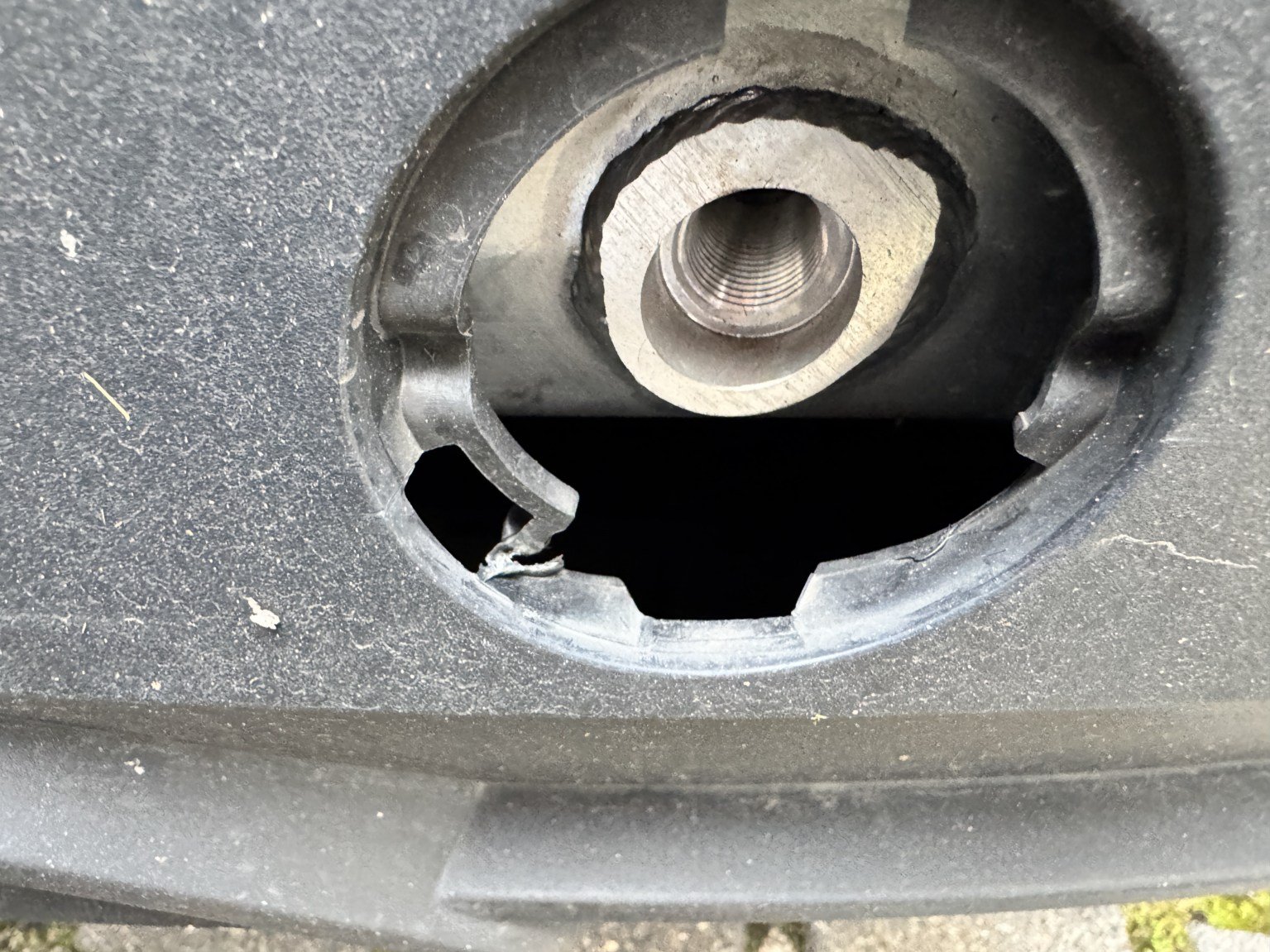 Detailaufnahme der aufgebrochenen Abdeckung der Anhängeöse im Heckstoßfänger des Tesla Model Y
